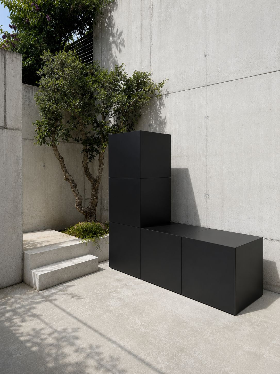 RO. matte black L-shaped bench composition against a concrete wall